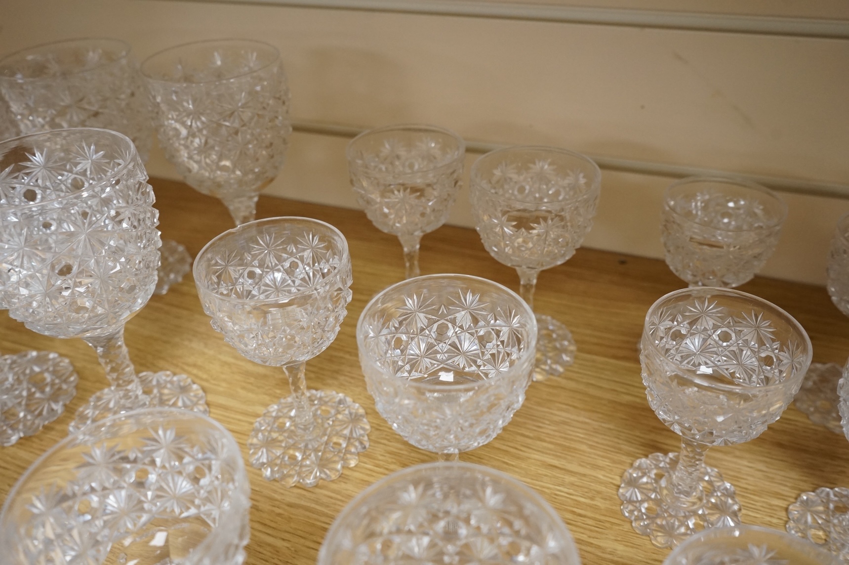 A Victorian heavy hobnail and star cut suite of table glass to include champagnes glasses and two decanters, largest 29cm high